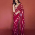 Sreeleela’s ruby red georgette sari is cut through with lines of mirror work